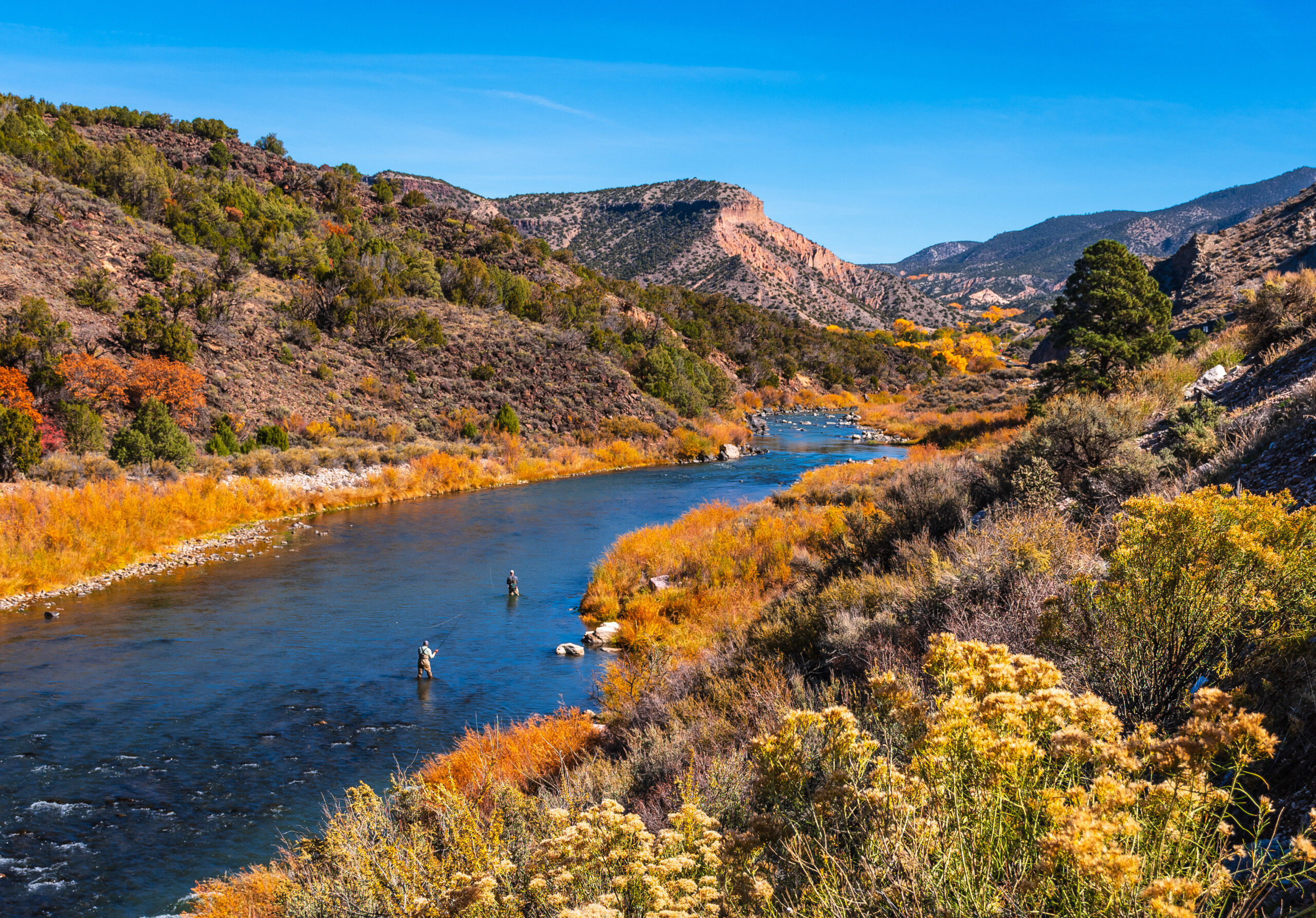 Beautiful autumn colors with fly fishermen on Rio Grande river flowing through New Mexico