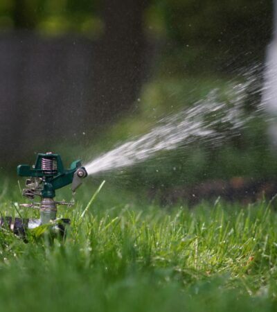 2025_Sprinkler_Unsplash A sprinkler running in a green yard